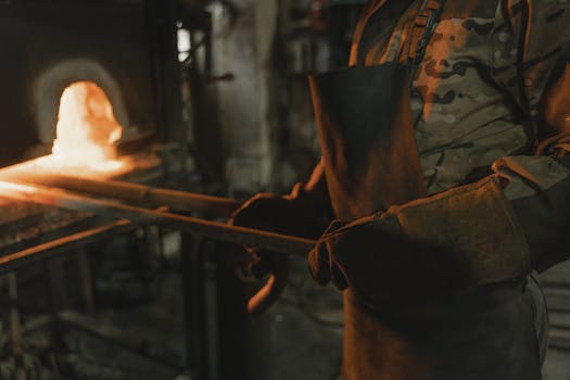 A blacksmith heats metal in a forge, demonstrating traditional metalworking skills.